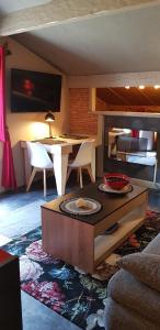 sala de estar con mesa, sofá y mesa en Appartement F2 tout confort **** en Saint-Jean-de-Luz