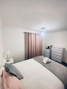 a bedroom with a large white bed and a dresser at Family Room close in Bristol +8 photos