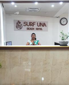 a woman standing behind the counter of a beach hotel at SURF UNA BEACH HOTEL in Unawatuna