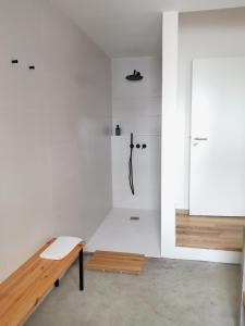 a white room with a bench and a shower at Terreiro Ocean House - Sea View in São Roque
