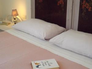a book sitting on top of a bed at B&B Il Gatto Pescatore in Stintino