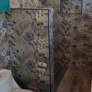 baño con aseo y papel pintado con motivos florales en Ecolodge Kalaluna Resort en Drake