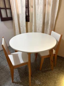 ein weißer Tisch und zwei Stühle neben einem Tisch andermottermott in der Unterkunft Dpto 1 Corrientes in Corrientes