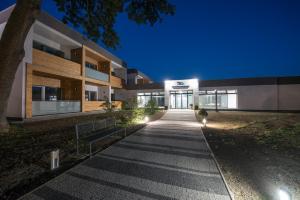 a walkway leading to a building at night at Termály Malé Bielice in Partizánske