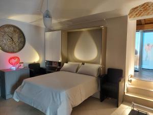 ein Schlafzimmer mit einem Bett, einer Uhr und einem Stuhl in der Unterkunft Dimora Rosso 27 in Fiano