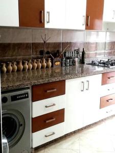 cocina con lavadora y encimera en Joli Appartement Vue Montagne en Xauen