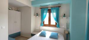 a bedroom with a window and a bed with blue pillows at Aracelia villas with private pool in Siviri +39 photos