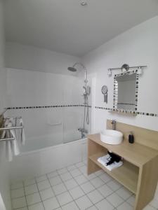 a bathroom with a sink and a shower and a tub at Hotel Helios - Golf in Salies-de-Béarn