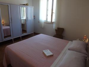 a bedroom with a bed with a book on it at B&B Il Gatto Pescatore in Stintino