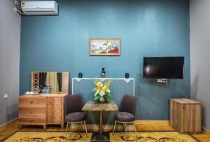 a room with a blue wall with a table and a tv at Prestige Boutique Hotel in Baku