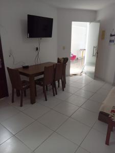 uma sala de jantar com uma mesa e cadeiras e uma televisão em Casa Carapibus Ale em Conde