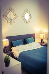 a bedroom with a blue bed and two lamps at Warren Apartment in London