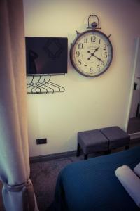 un reloj en la pared de un dormitorio en Warren Apartment, en Londres