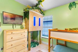 基西米的住宿－Beautiful Tropical Home with Private Heated and Chilled Pool，一间带绿色墙壁和木制梳妆台的卧室