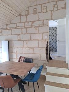 uma sala de jantar com uma mesa de madeira e cadeiras azuis em Atypique Saumur 80 m2 joli appartement 2 à 7 pers familial rénové entier 3 chambres hyper centre em Saumur