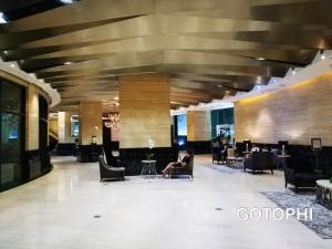 a person sitting in a chair in a lobby at The Gramercy Residences in Manila