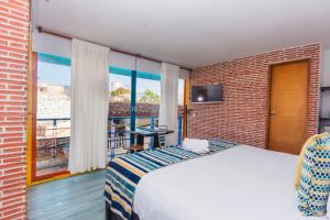 una camera d'albergo con un letto e un balcone di Hotel Guatatur a Guatapé