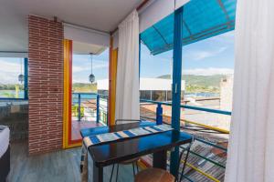 balcón con mesa azul y vistas en Hotel Guatatur en Guatapé