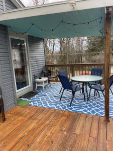 a patio with a table and chairs on a deck at Quite Cozy Wooded Hideaway in Livingston Manor