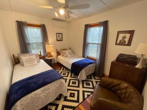 a bedroom with two beds and a chair in it at Quite Cozy Wooded Hideaway in Livingston Manor