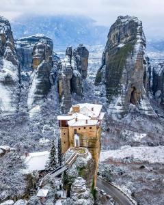 a building on the side of a mountain in the snow at Kalian Meteora in Kalabaka