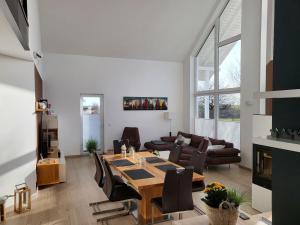 a living room with a wooden table and chairs at modernes Ferienhaus mit Kamin, Garten und eigener Sauna - Ferienhaus Meerfreude in Vaschvitz