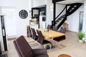 a dining room with a wooden table and chairs at modernes Ferienhaus mit Kamin, Garten und eigener Sauna - Ferienhaus Meerfreude in Vaschvitz