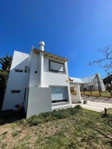 uma casa branca com uma porta em cima de um quintal em Apart Nivel Cero em Monte Hermoso