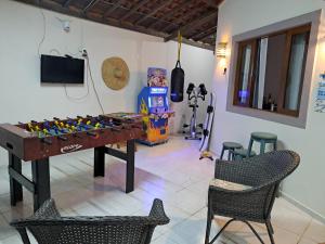 Habitación con mesa de futbolín, sillas y TV. en Maravilha em Tibau do Sul en Tibau do Sul