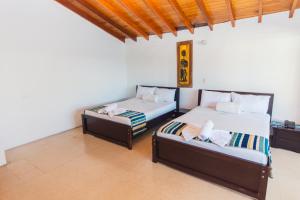 2 camas y un sofá en una habitación en Hotel Guatatur en Guatapé
