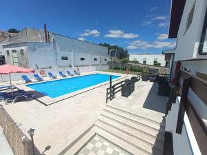 a swimming pool with lounge chairs next to a building at Aparthotel QuintadaCostinha Alijó Douro in Alijó