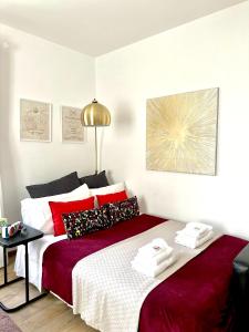 una camera con letto e lenzuola rosse e bianche di Gemelli-San Pietro-Trastevere-casa con posto auto a Roma