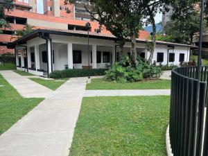 a building with a fence next to a sidewalk at Feel at home in Sabaneta