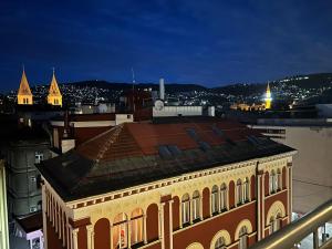 a building with a view of a city at night at Sarajevo Skyline Apartment in Sarajevo