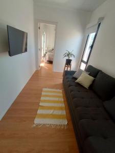 sala de estar con sofá y TV en Casa Cajita en Rancul