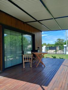 un patio con una mesa y un banco en una terraza en Casa Cajita en Rancul