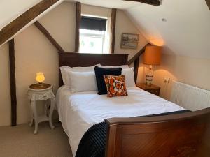 um quarto com uma cama com lençóis brancos e almofadas em The Old Workhouse Paddocks em Bawdeswell