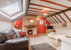 ein Wohnzimmer mit einem Sofa und einem Kamin in der Unterkunft Granary Cottage in Swimbridge