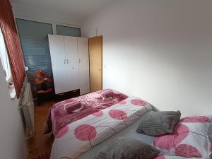 a bedroom with a bed with pink hearts on it at Apartman Ante in Gospić