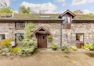 an old stone house with a wooden door at Granary Cottage in Swimbridge