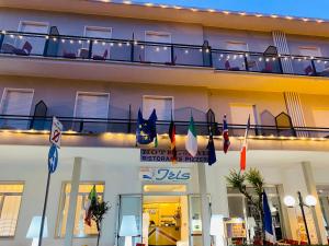 a hotel exterior with a balcony with flags on it at hotel iris in Rimini