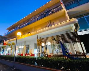 ein Gebäude mit einem Restaurant mit einem blauen Sonnenschirm im Freien in der Unterkunft hotel iris in Rimini