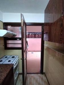 uma cozinha com uma porta aberta para uma cozinha com um fogão em Departamento en Mar del Plata em Mar del Plata