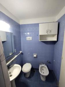 uma casa de banho em azulejos azuis com um WC e um lavatório em Departamento en Mar del Plata em Mar del Plata