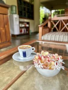 a cup of coffee and a bowl of fruit on a table at Jungle Paradise in Udawalawe