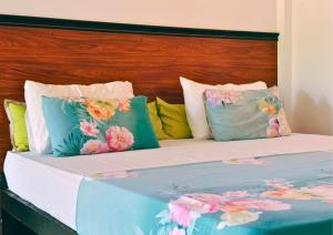 una cama con almohadas coloridas encima en AMOUR AT TURTLE BEACH, en Tangalle
