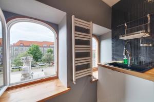 een keuken met een spoelbak en een raam bij Dream Loft Motlava River in Gdańsk +26 foto's