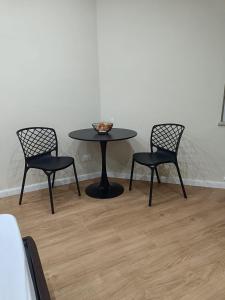 a black table with two chairs and a bowl on it at HOB Via Rausei in Reggio Calabria