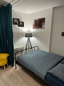 1 dormitorio con 1 cama y 1 silla amarilla en Appartement avec vue sur jardin Paris-Disney-Parking privé 'PKN MEAUX', en Meaux