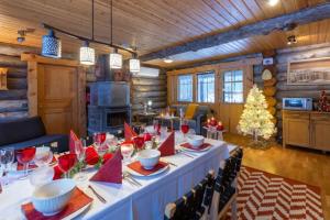 a long table in a room with a christmas tree at Kuukkeli Log Houses Villa Aurora "Pupula" in Saariselka